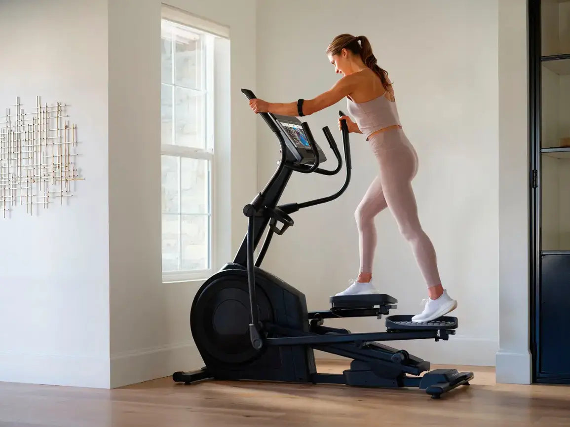 A girl using NordicTrack Airglide 14i Elliptical Crosstrainer at home gym for cardio